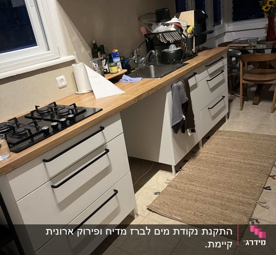 מטבח עם כיור מלא כלים, מגבת תלויה